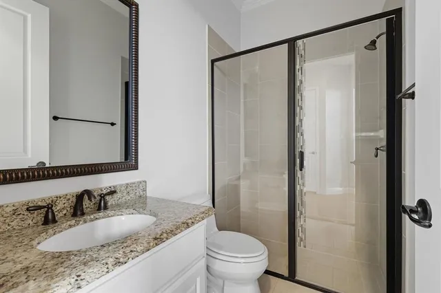 a bathroom with a granite countertop sink toilet and shower