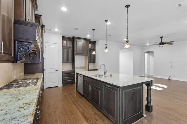 a kitchen with kitchen island a sink appliances and cabinets