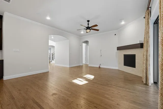 a view of empty room with wooden floor and fireplace