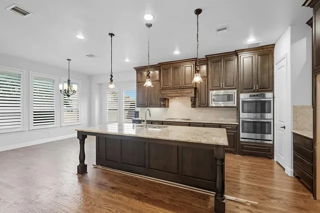 a large kitchen with kitchen island a large island in it