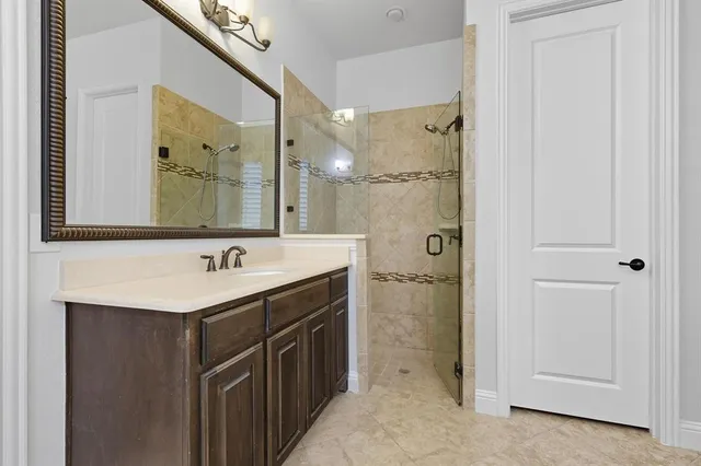 a bathroom with a sink a mirror a vanity and a shower