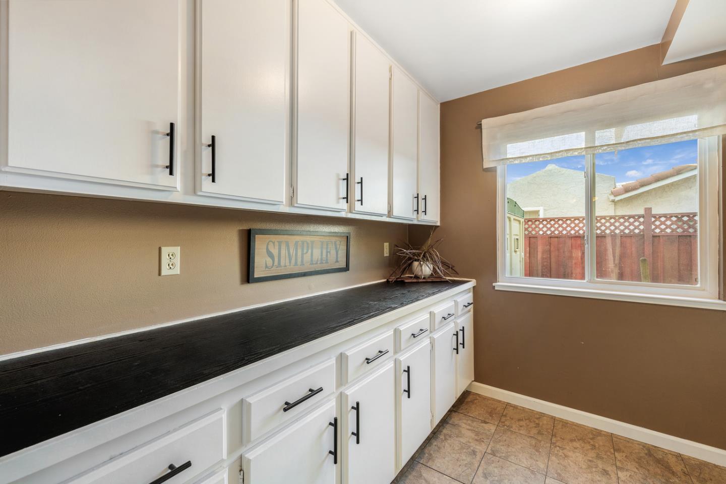 6479 Barron Place Gilroy, CA 95020 - Photo 19 of 26 a kitchen with granite countertop white cabinets and window