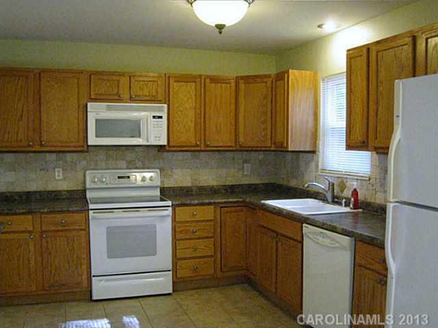 4242 Sudbury Road Charlotte, NC 28205 - Photo 4 of 16 a kitchen with a sink stove and microwave
