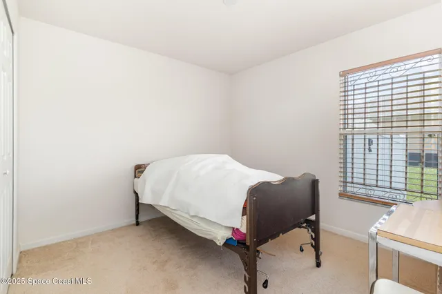 a bed sitting in a bedroom next to a window