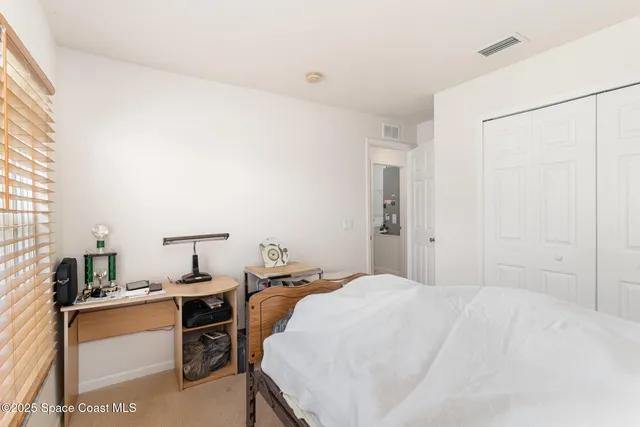 a bedroom with a bed and a desk in it