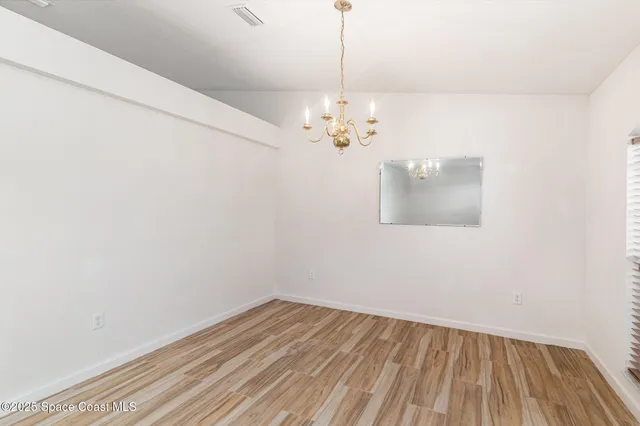 a view of a room with wooden floor and chandelier