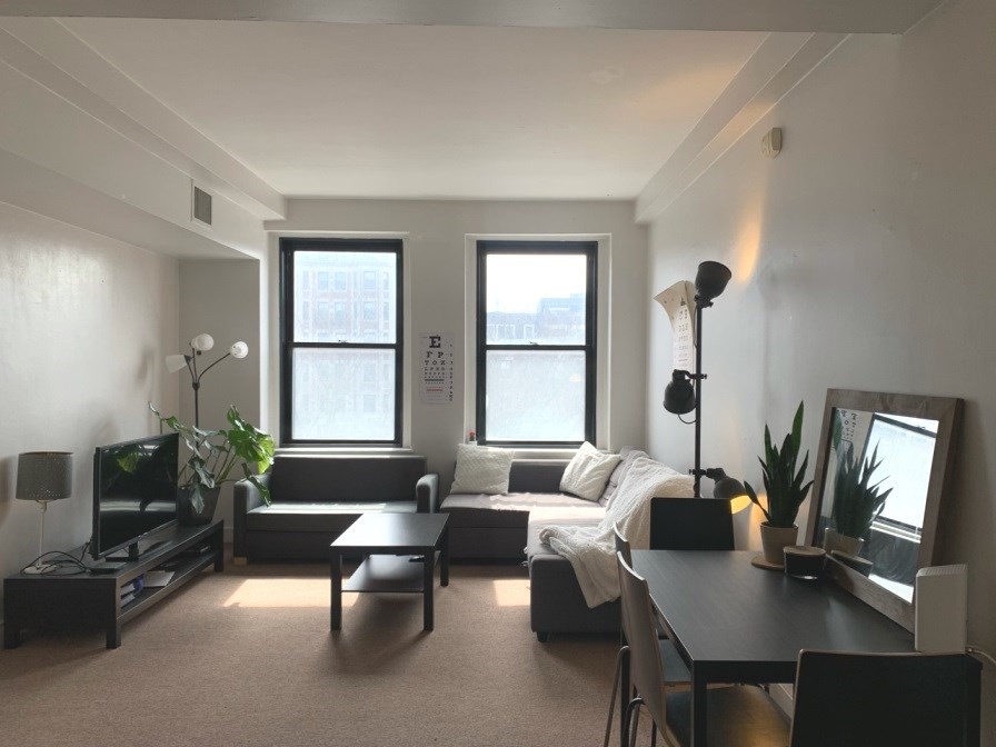 a living room with furniture a large window and a flat screen tv