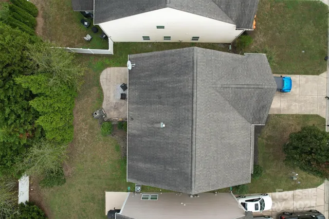 an aerial view of a house with a yard and large tree