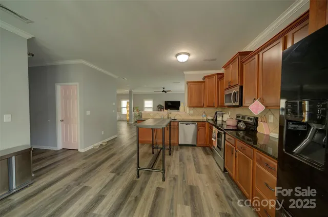 a kitchen with kitchen island granite countertop lots of counter top space and stainless steel appliances
