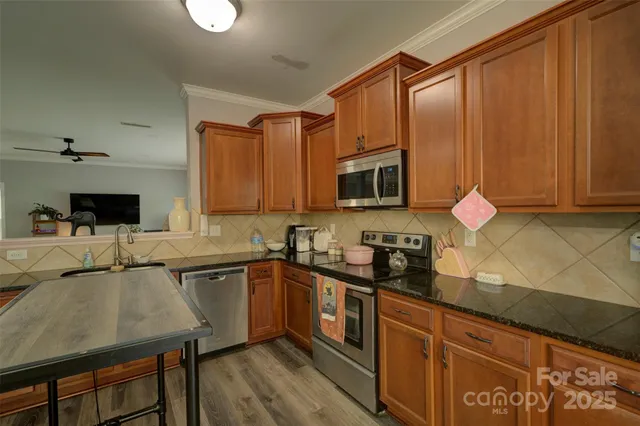 a kitchen with stainless steel appliances granite countertop a sink microwave and cabinets