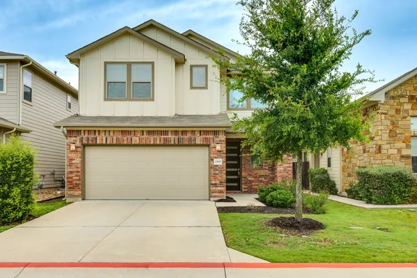 a front view of a house with a yard and garage