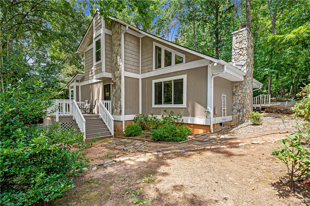 139 Tulip Lane Westminster, SC 29693 - Photo 21 of 37 A secluded dwelling nestled amidst verdant trees, showcasing a blend of natural stone and wood siding.