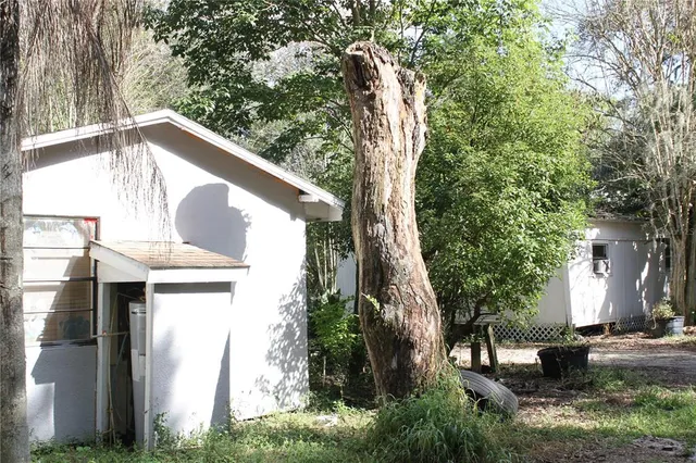 a view of a house with a tree and a yard