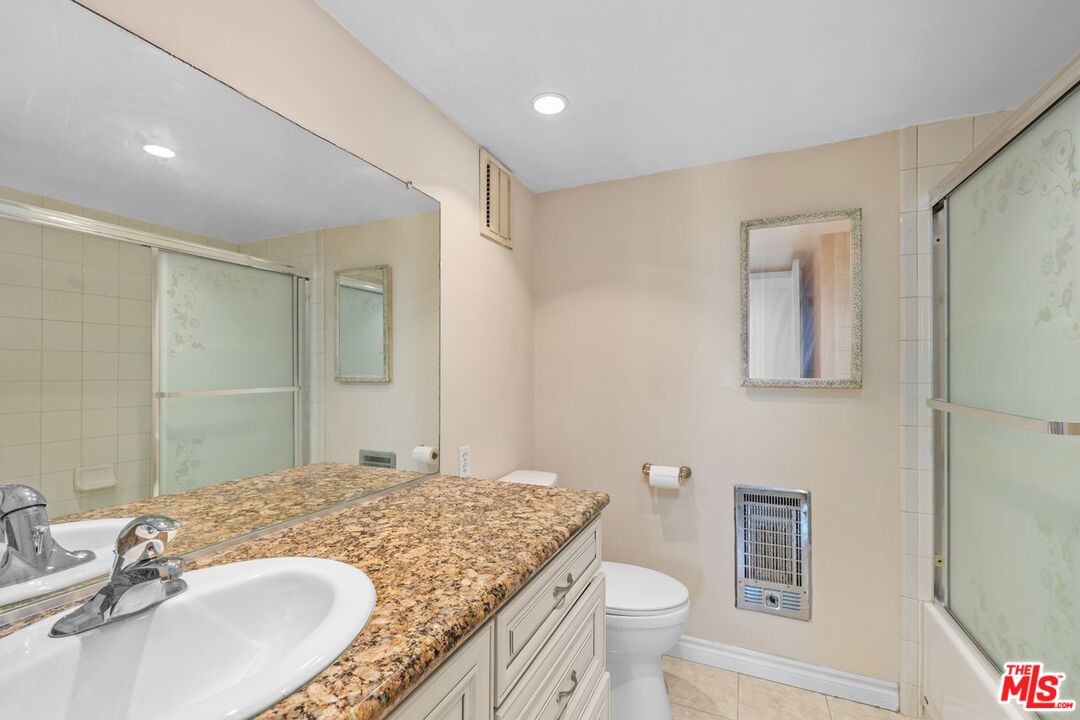 10535 Wilshire Boulevard, Unit 801 Los Angeles, CA 90024 - Photo 15 of 53 a bathroom with a granite countertop sink toilet and shower