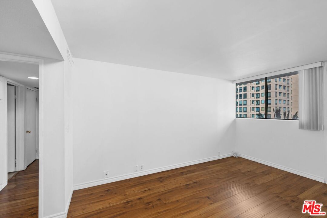 10535 Wilshire Boulevard, Unit 801 Los Angeles, CA 90024 - Photo 16 of 53 a view of an empty room with wooden floor and a window