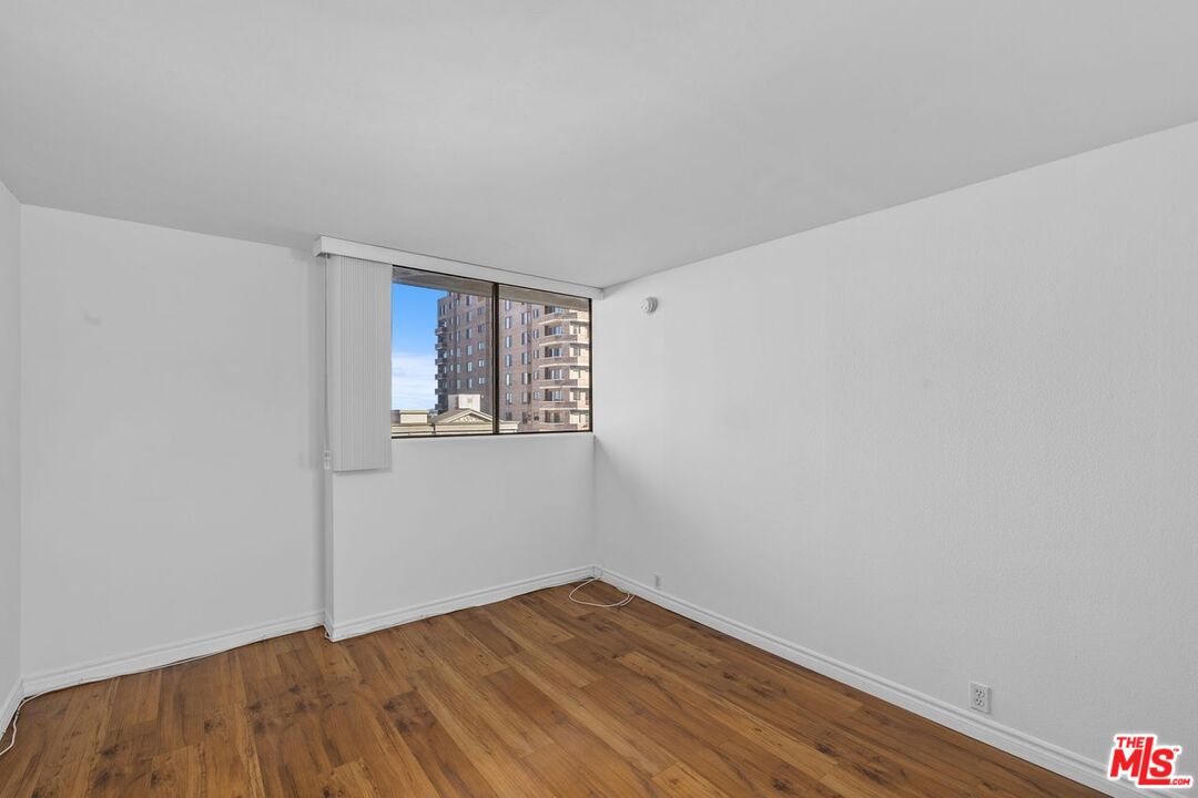 10535 Wilshire Boulevard, Unit 801 Los Angeles, CA 90024 - Photo 17 of 53 a view of an empty room with wooden floor and a window