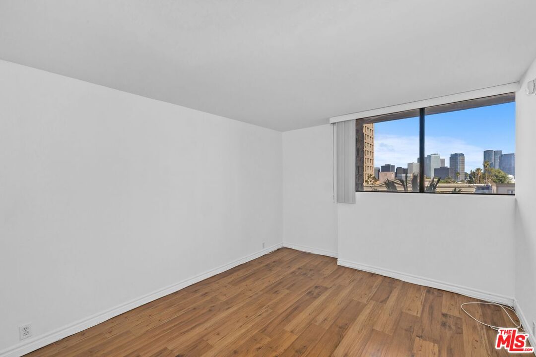 10535 Wilshire Boulevard, Unit 801 Los Angeles, CA 90024 - Photo 18 of 53 a view of an empty room with wooden floor and a window