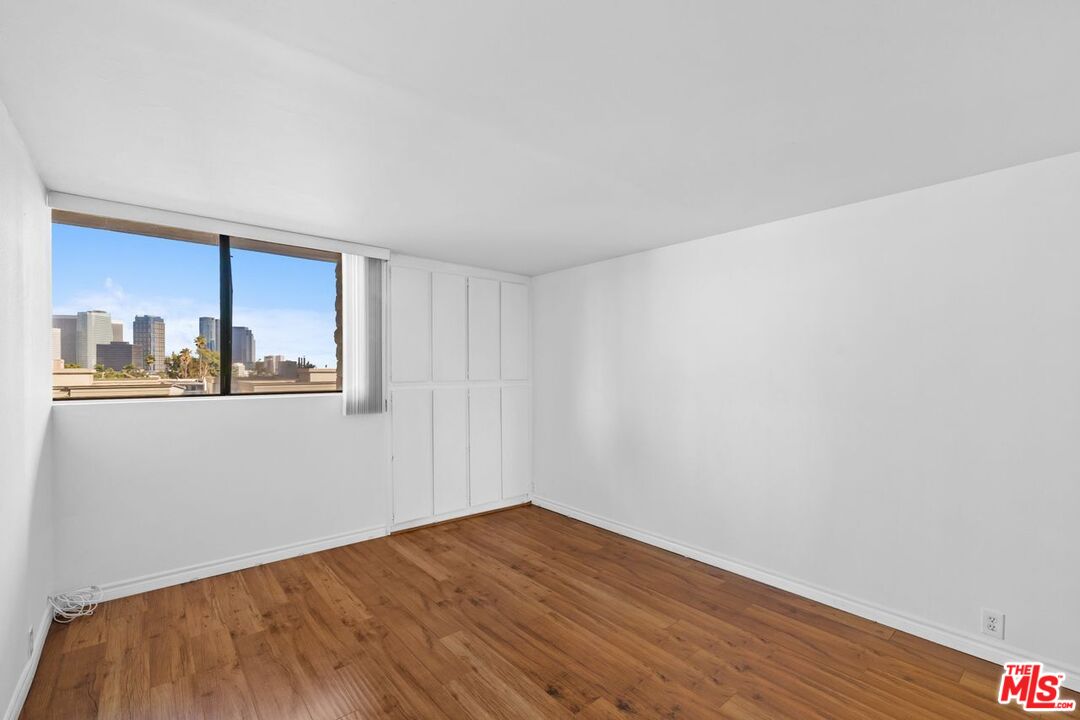 10535 Wilshire Boulevard, Unit 801 Los Angeles, CA 90024 - Photo 23 of 53 a view of an empty room with wooden floor and a window
