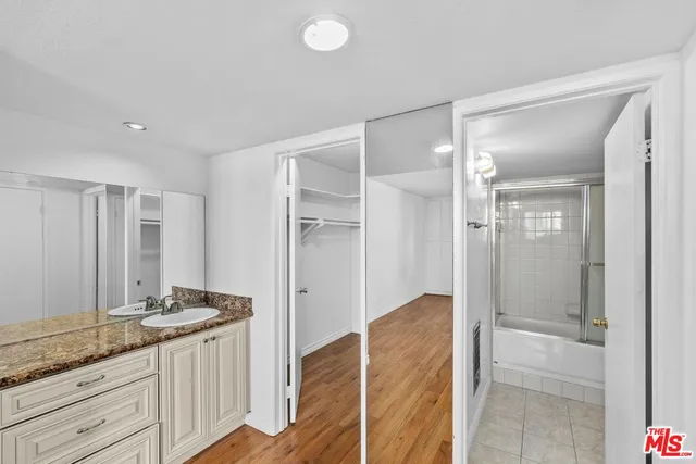 a bathroom with a granite countertop sink and a mirror