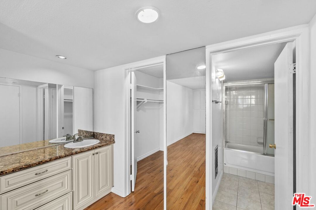 10535 Wilshire Boulevard, Unit 801 Los Angeles, CA 90024 - Photo 25 of 53 a bathroom with a granite countertop sink and a mirror