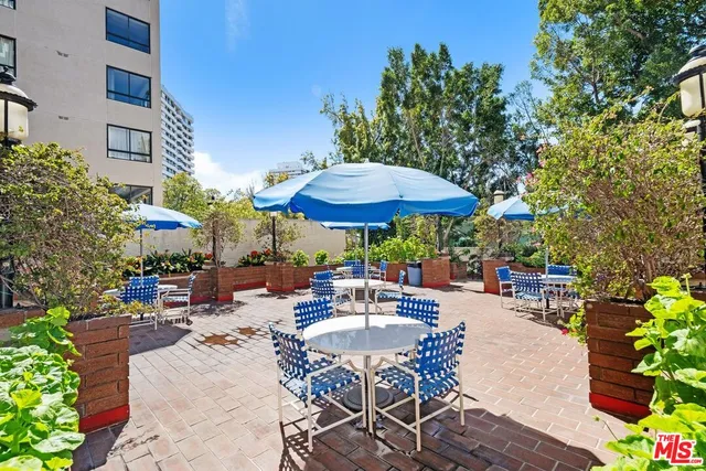 a view of a tables and chairs under an umbrella in patio