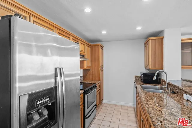 a kitchen with stainless steel appliances granite countertop a refrigerator and a sink