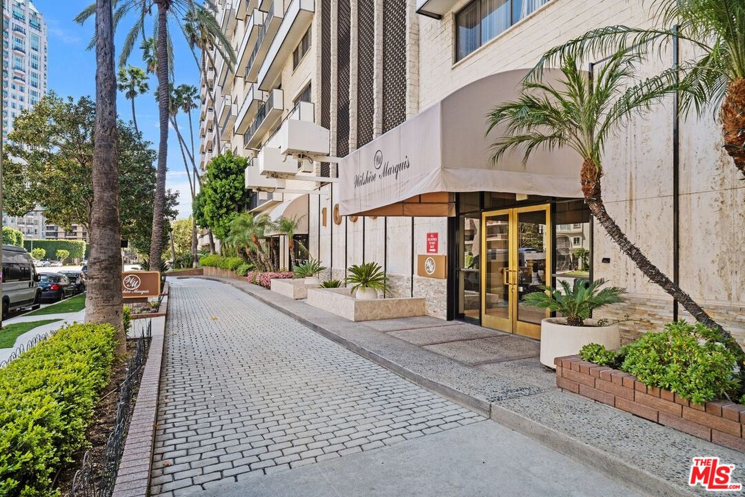 10535 Wilshire Boulevard, Unit 801 Los Angeles, CA 90024 - Photo 51 of 53 a view of a building with a bench under a large tree