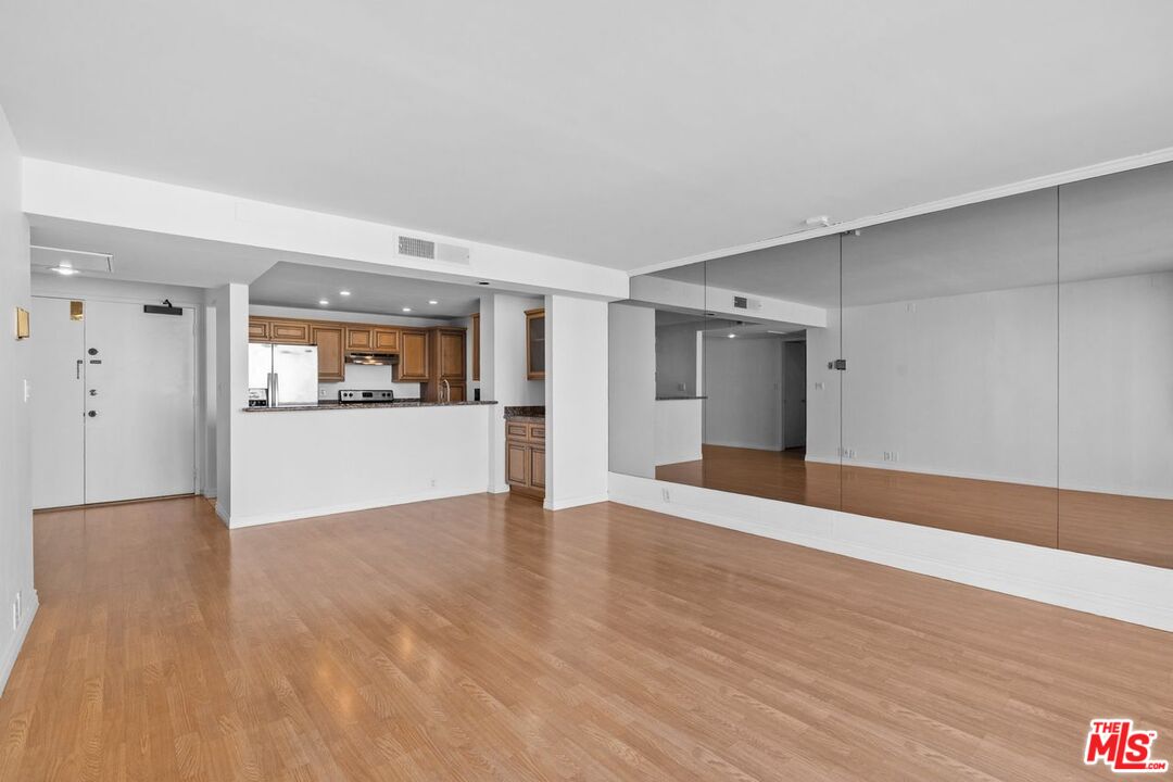 10535 Wilshire Boulevard, Unit 801 Los Angeles, CA 90024 - Photo 9 of 53 a view of a kitchen with wooden floor and a refrigerator