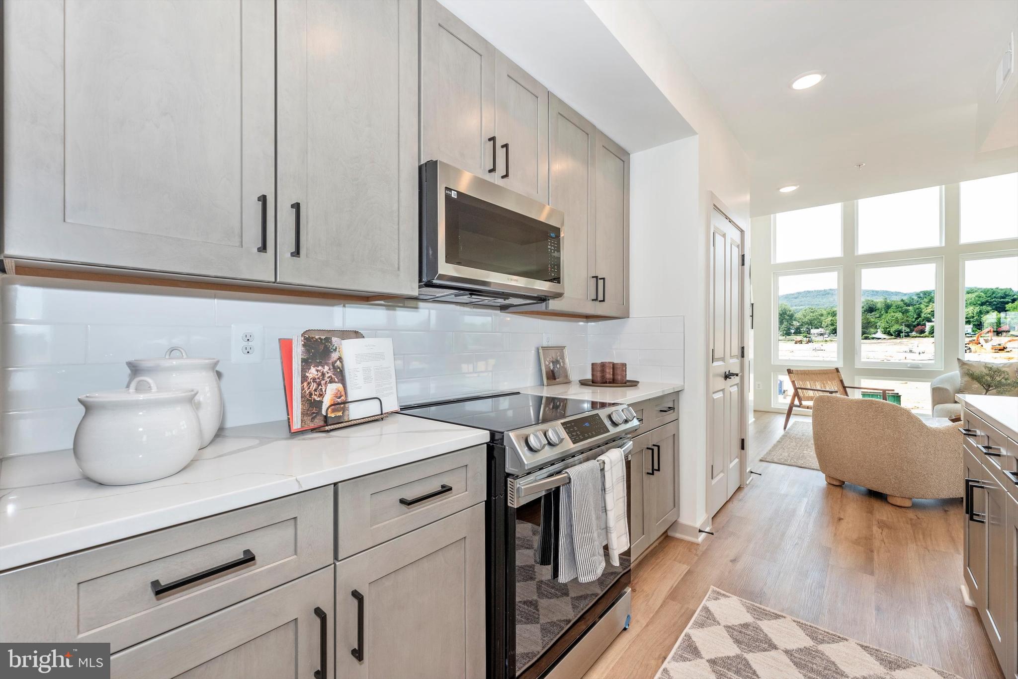 710 D Iron Frg Road Frederick, MD 21702 - Photo 18 of 37 a kitchen with stainless steel appliances granite countertop a stove a sink dishwasher and white cabinets with wooden floor