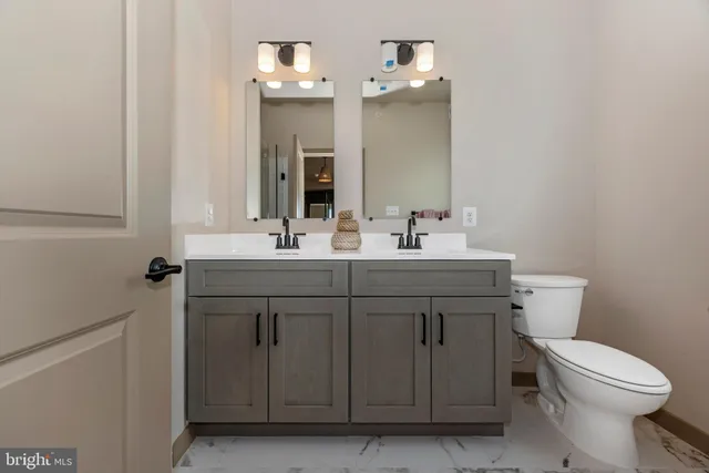 a bathroom with a sink vanity and a toilet