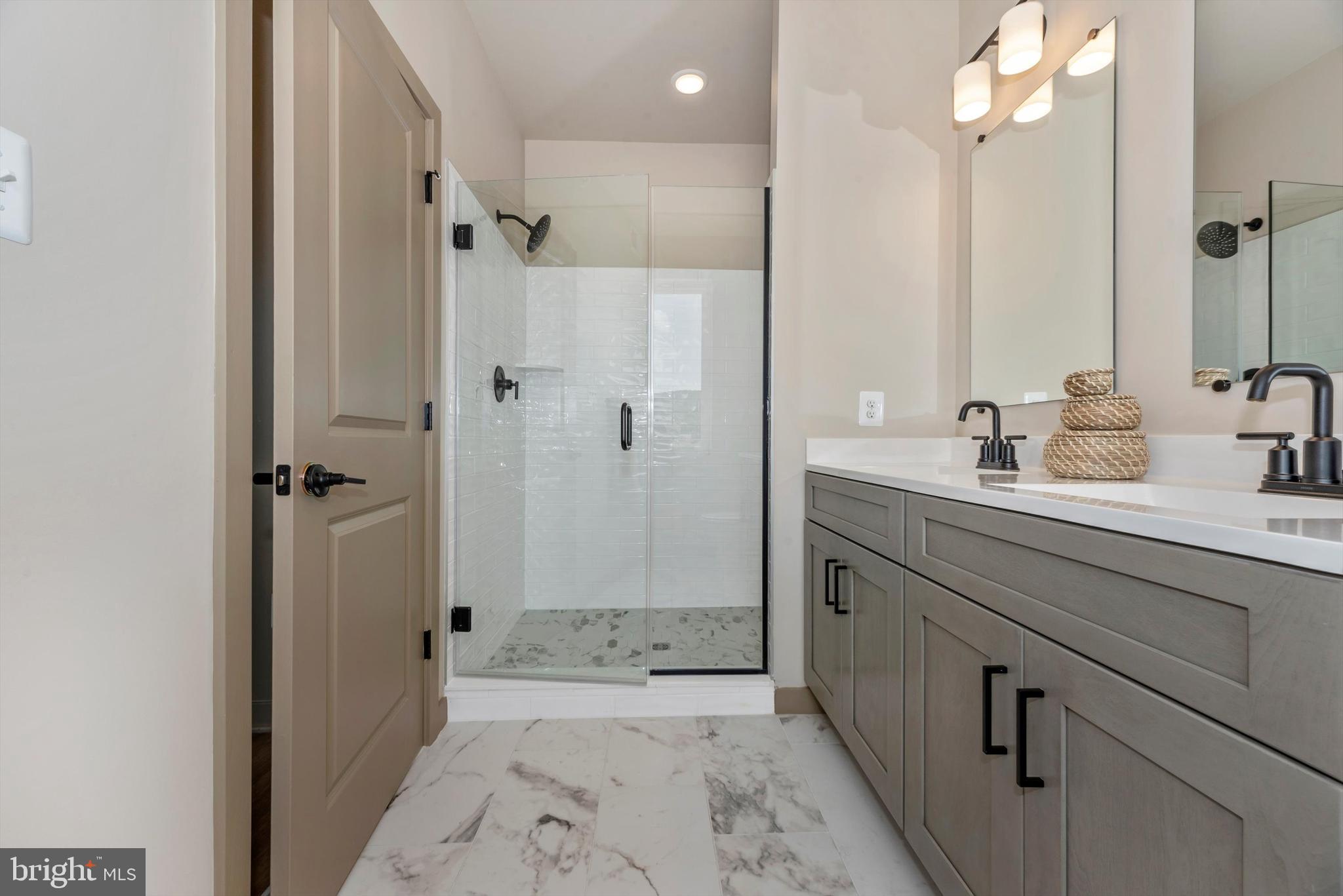 710 D Iron Frg Road Frederick, MD 21702 - Photo 29 of 37 a bathroom with a shower sink and mirror