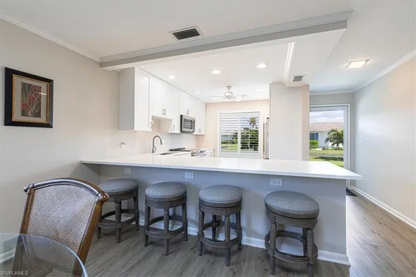 a kitchen with a table chairs sink and cabinets