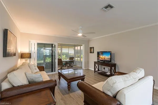 a living room with furniture a flat screen tv and a large window