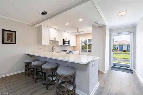 a kitchen with sink and chairs