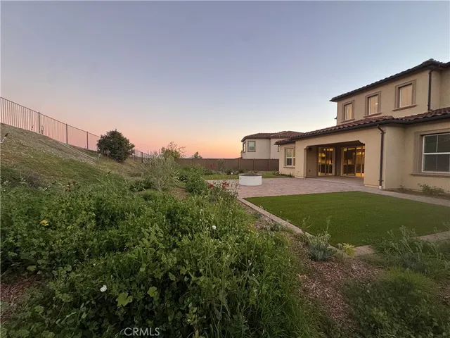 a view of a house with a big yard plants and large trees