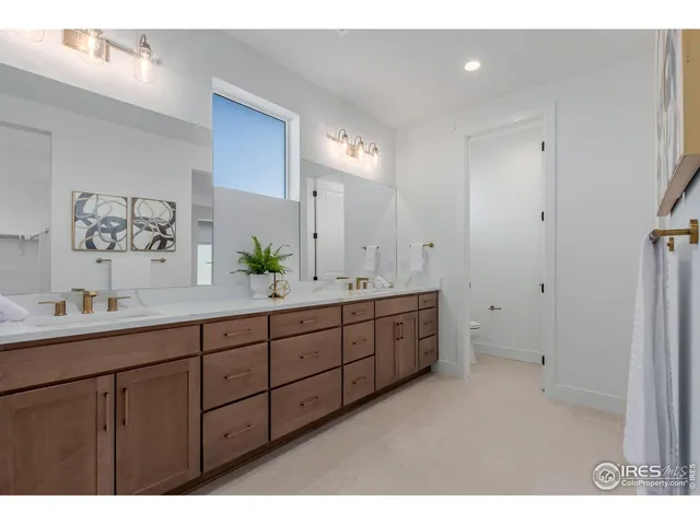 a bathroom with double vanity sinks a vanity a lamp and a shower