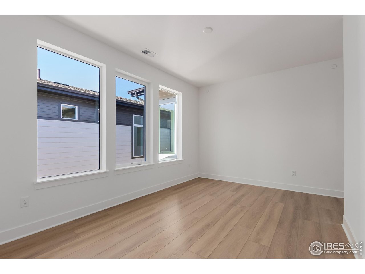 674 Apex Street Erie, CO 80516 - Photo 24 of 47 a view of an empty room with wooden floor and a window