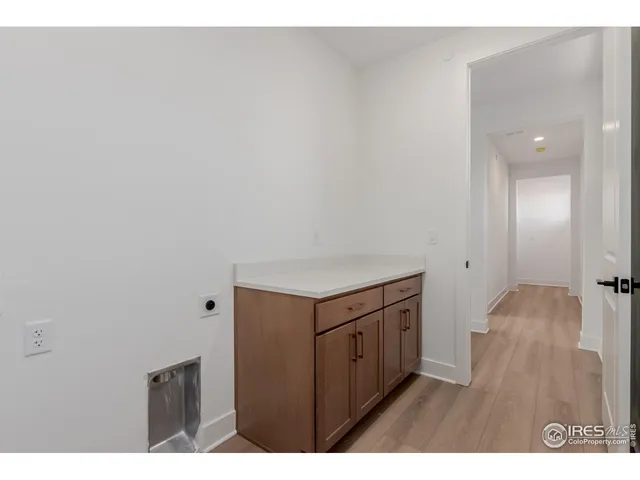 a kitchen with cabinets and wooden floor