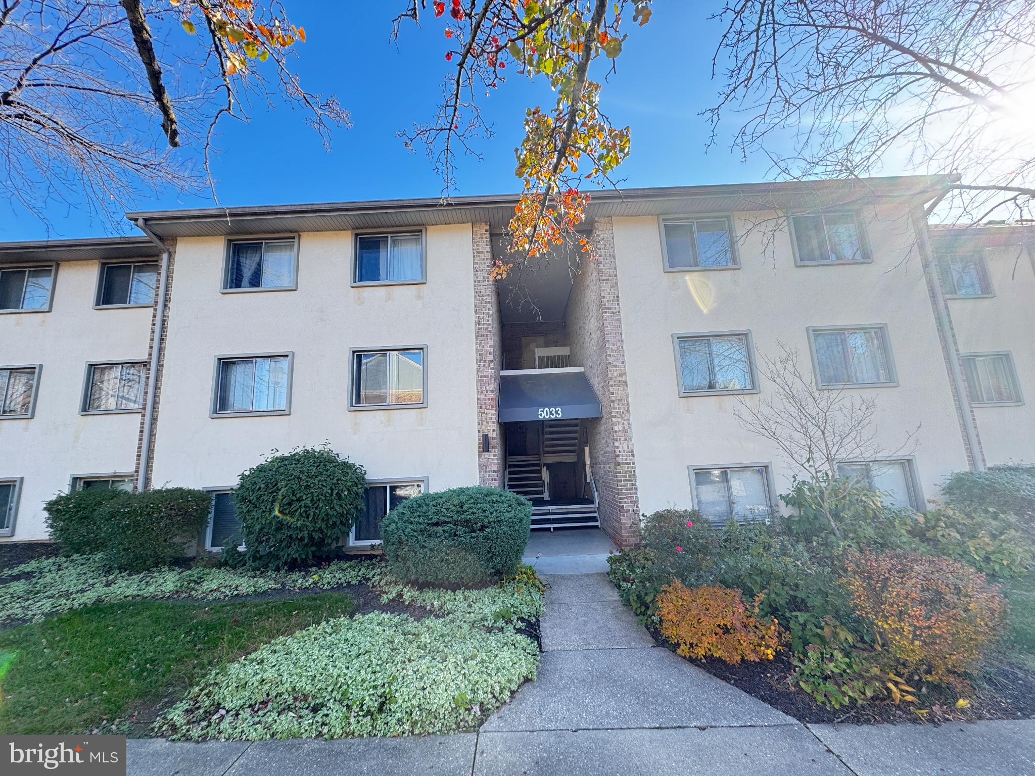 Charming apartment building with lush landscaping.