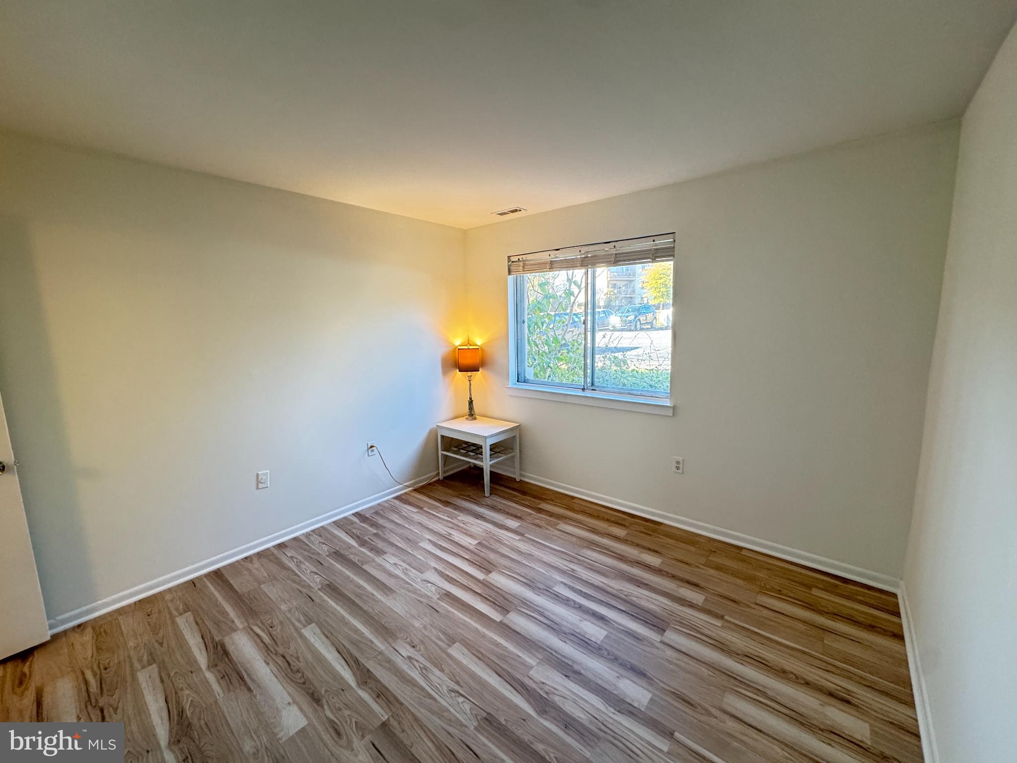 5033 Green Mountain Circle, Unit 2 Columbia, MD 21044 - Photo 22 of 40 a view of an empty room with a window and wooden floor