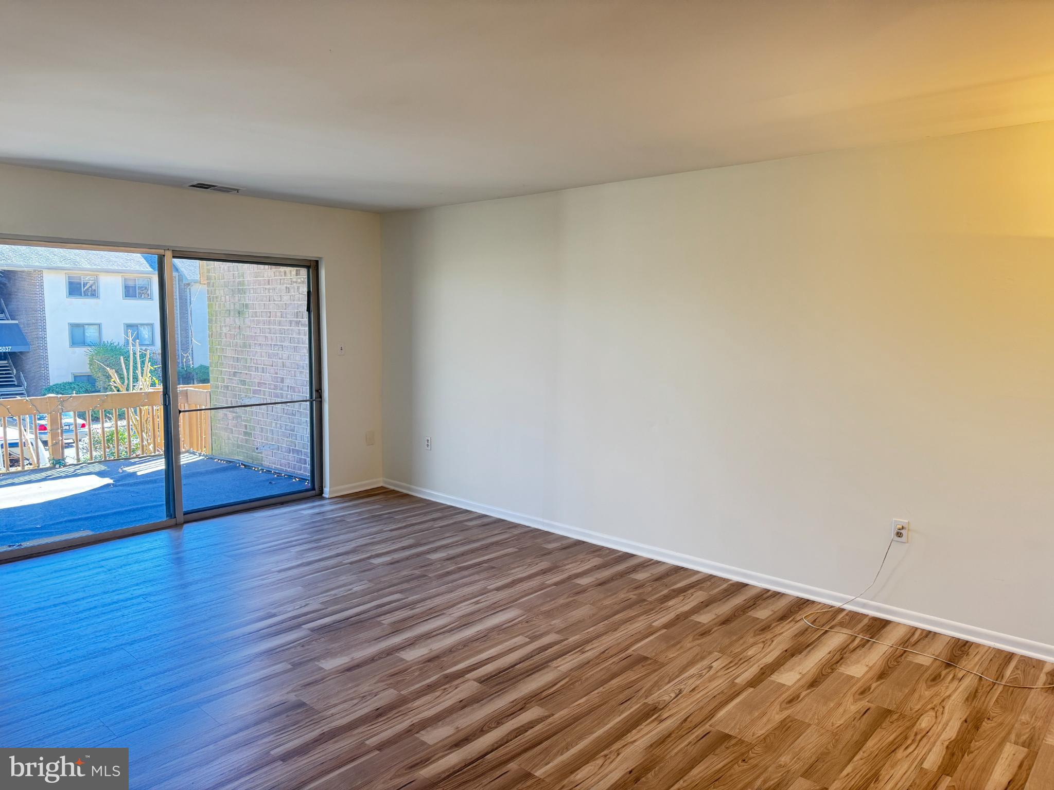 5033 Green Mountain Circle, Unit 2 Columbia, MD 21044 - Photo 3 of 40 a view of an empty room with wooden floor and a window