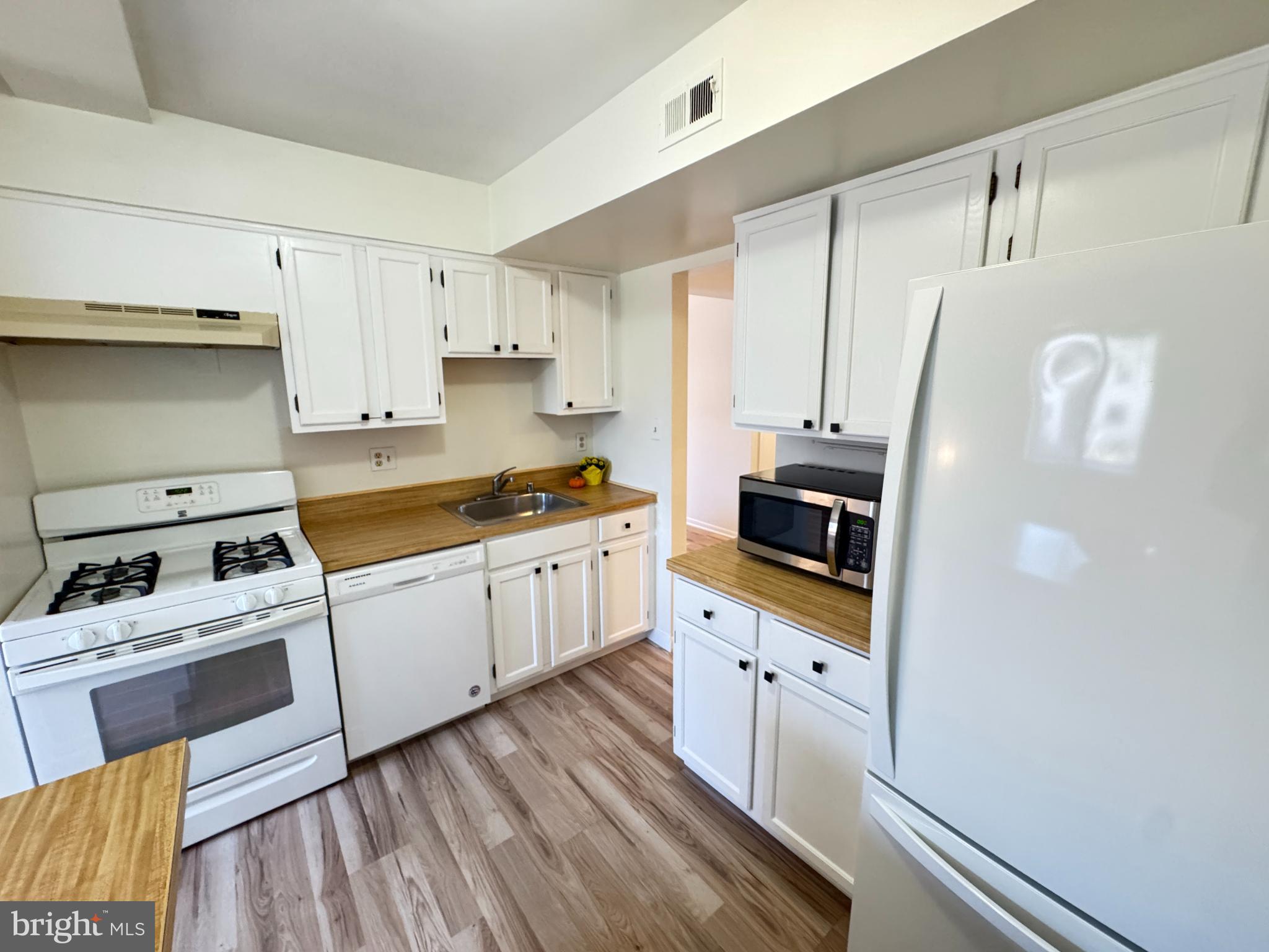 5033 Green Mountain Circle, Unit 2 Columbia, MD 21044 - Photo 6 of 40 a kitchen with granite countertop white cabinets and white appliances