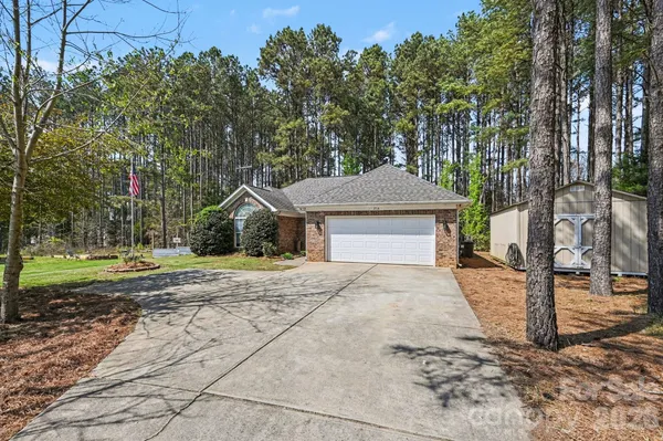 a front view of a house with a yard and tree