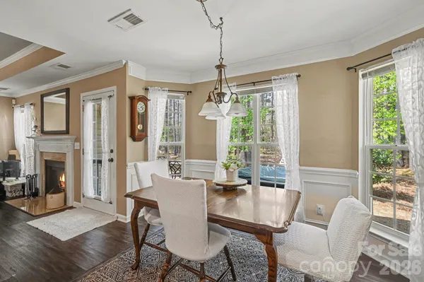 a view of a dining room with furniture large windows and wooden floor