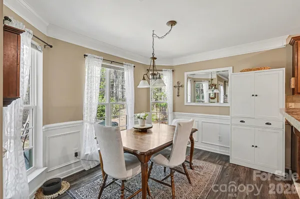 a dining room with furniture a chandelier and wooden floor