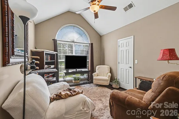 a living room with furniture a flat screen tv and a large window