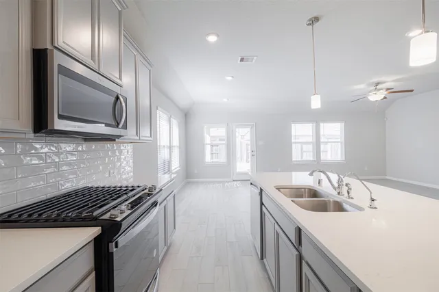 a kitchen that has a sink and a stove top oven