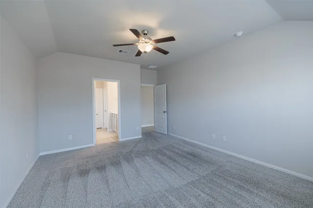 a view of an empty room with a chandelier fan