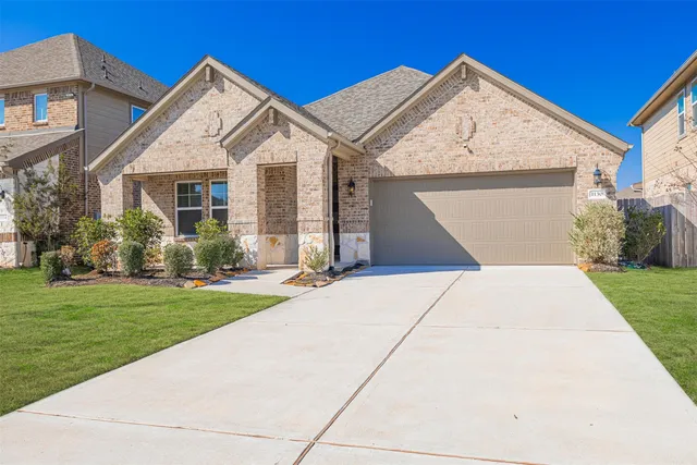 a view of a white house next to a yard with big trees
