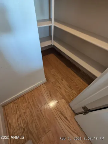 a view of a hallway with wooden floor and stairs
